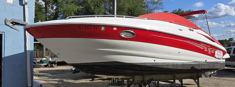 Slide: The Image of 2006 Crownline 255 CCR boat with red and white exterior, docked outdoors. - 22
