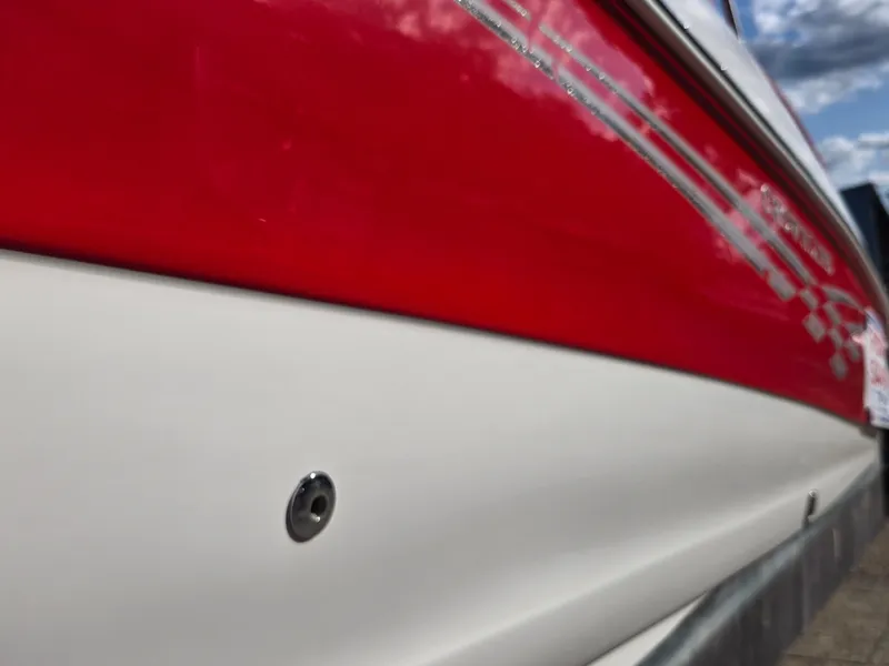 Slide: The Image of Red and white 2006 Crownline 255 CCR boat hull with sleek design. - 27