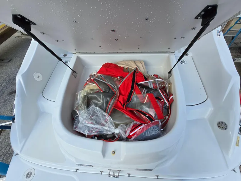 Slide: The Image of Open storage compartment of 2006 Crownline 255 CCR boat with red and gray items inside. - 32