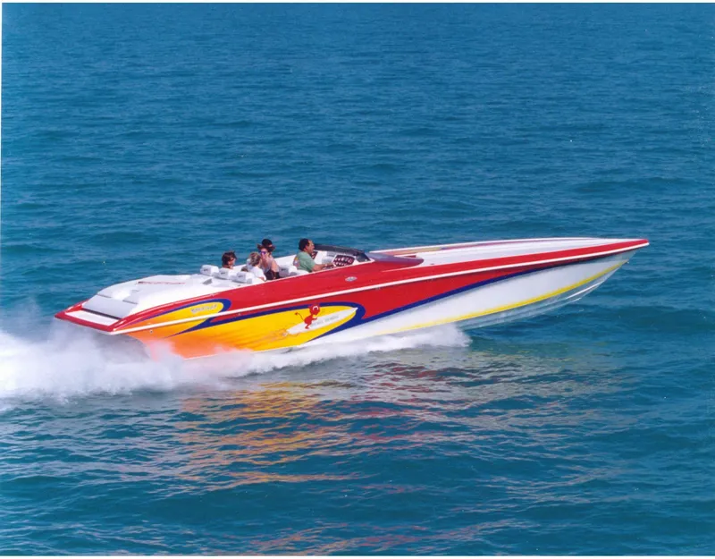 The Image of Red and yellow 2004 Hustler 388 SLINGSHOT speedboat cruising on blue ocean water. - 1