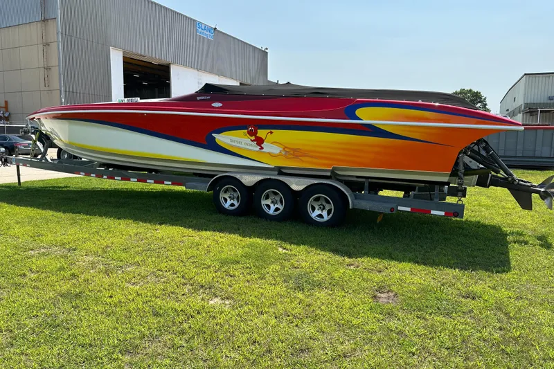 Slide: The Image of 2004 Hustler 388 SLINGSHOT speedboat on trailer, vibrant red and yellow design. - 12
