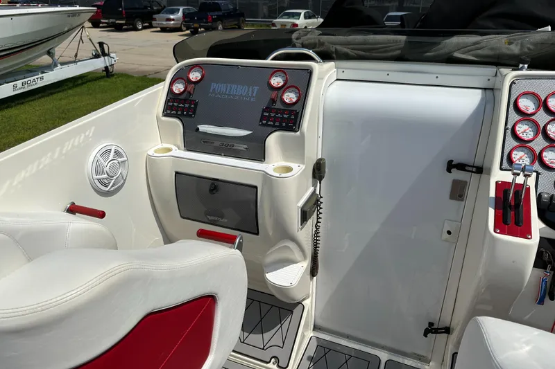 Slide: The Image of 2004 Hustler 388 SLINGSHOT boat dashboard with gauges and white-red seating. - 13