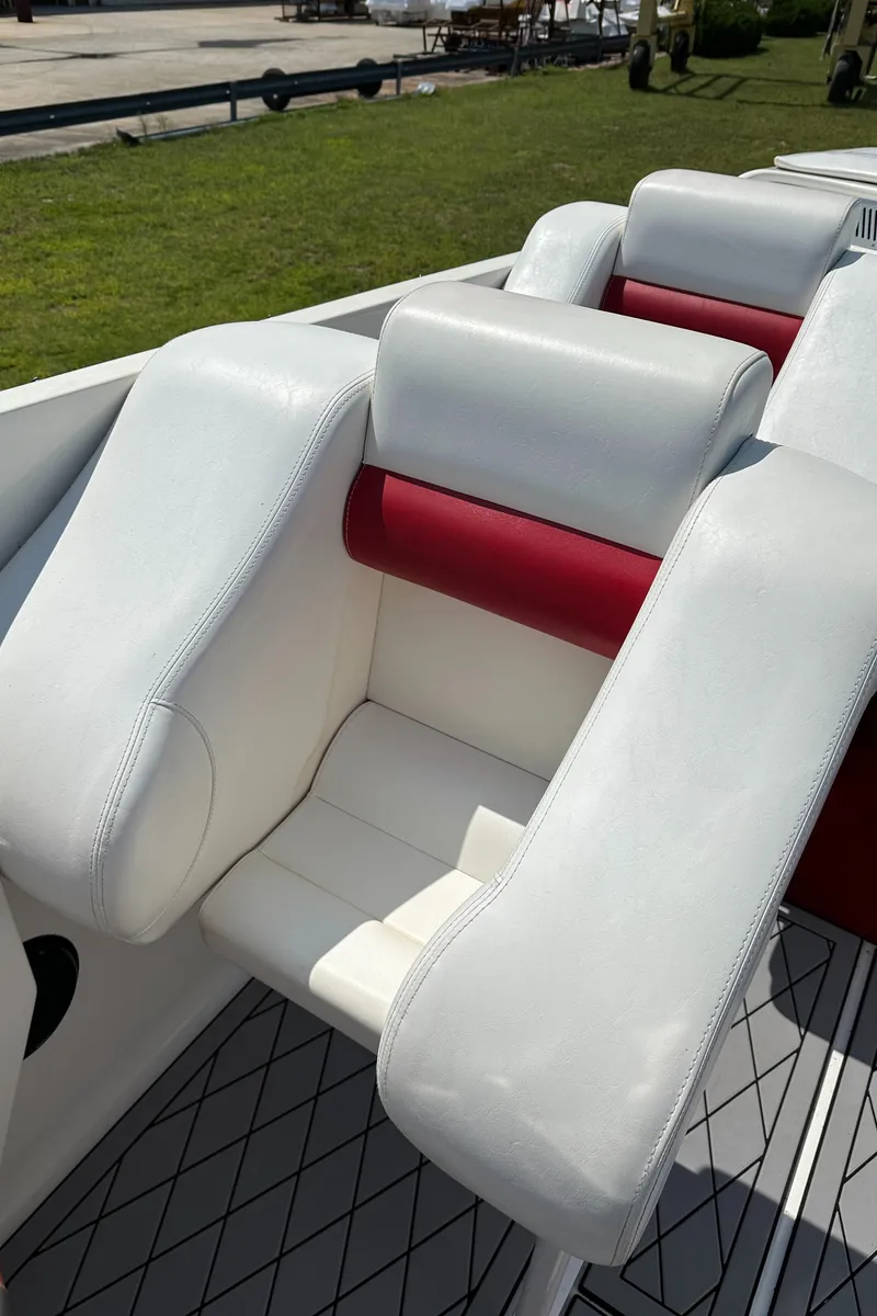 Slide: The Image of 2004 Hustler 388 SLINGSHOT boat interior with white and red seating. - 16