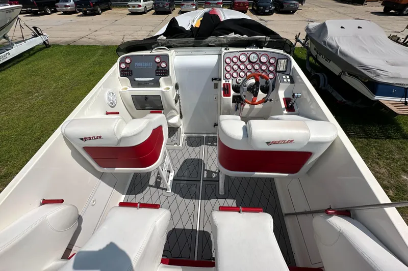 Slide: The Image of 2004 Hustler 388 SLINGSHOT boat interior with red and white seating, dashboard, and controls. - 20