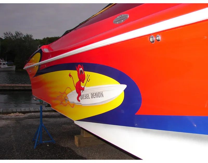 Slide: The Image of 2004 Hustler 388 SLINGSHOT boat with vibrant red and yellow design, "Diesel Demon" graphic. - 4