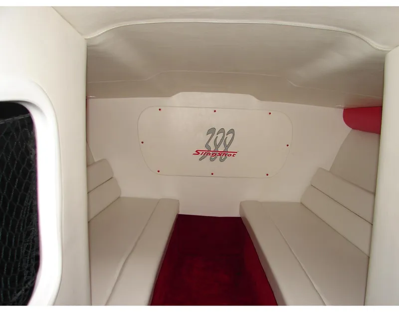 Slide: The Image of Interior of 2004 Hustler 388 SLINGSHOT boat with white seating and red carpet. - 8
