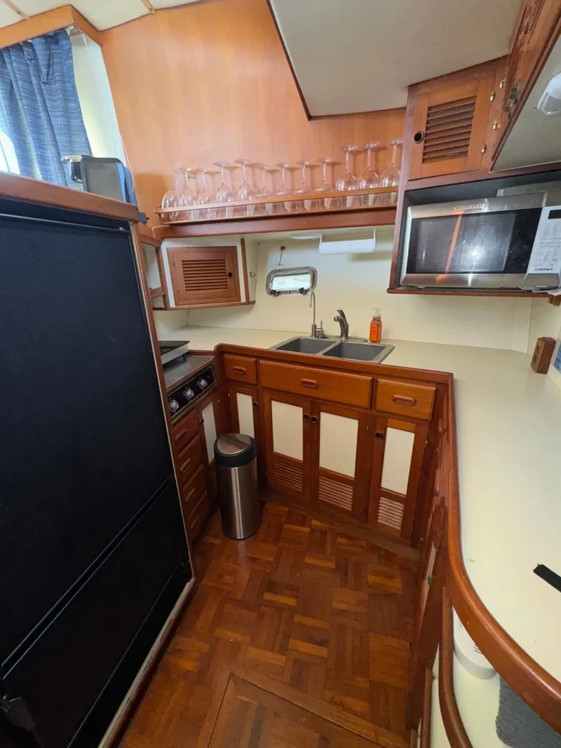 Slide: The Image of 1987 Kadey-Krogen Silhouette yacht kitchen with wood cabinetry, microwave, and sink. - 11