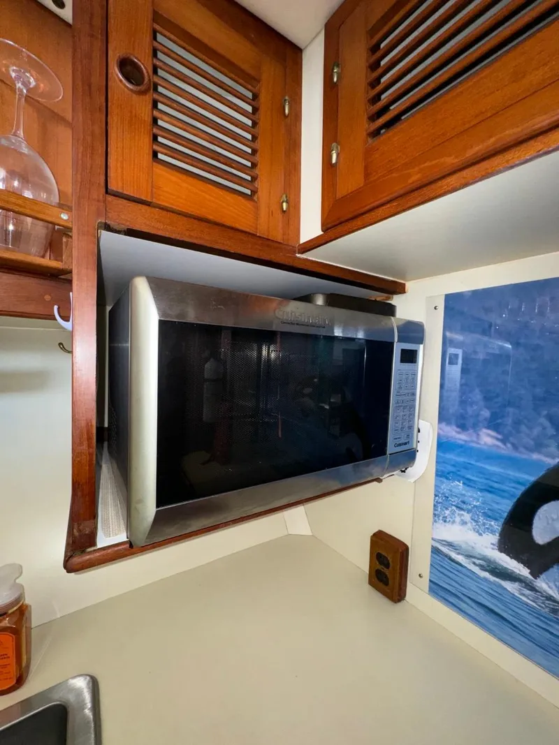 Slide: The Image of Microwave in 1987 Kadey-Krogen Silhouette yacht kitchen with wooden cabinets and ocean view. - 15