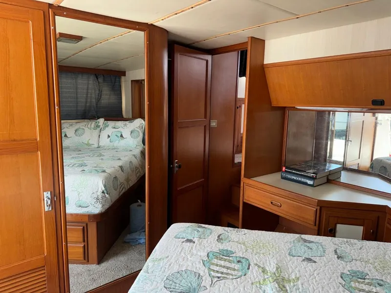 Slide: The Image of 1987 Kadey-Krogen Silhouette interior with wood paneling, cozy bed, and mirrored closet. - 19