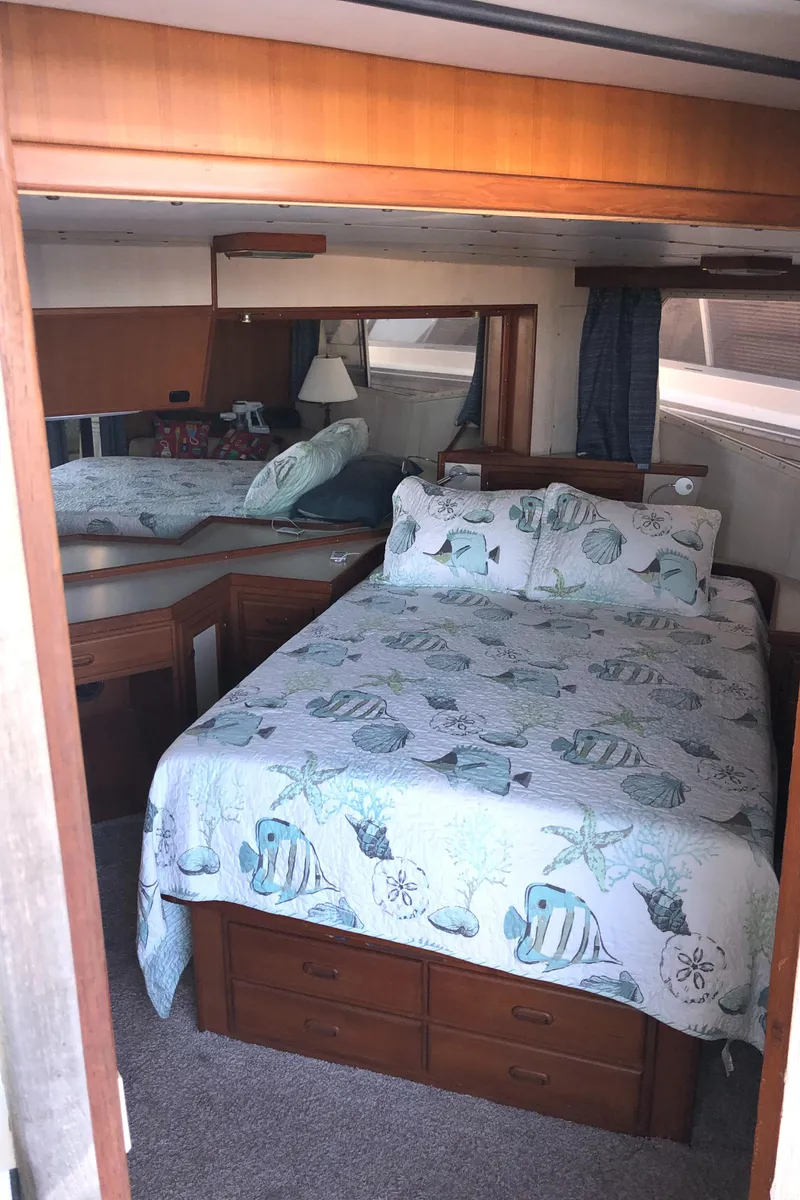 Slide: The Image of 1987 Kadey-Krogen Silhouette bedroom with nautical-themed bedding and wooden furnishings. - 20