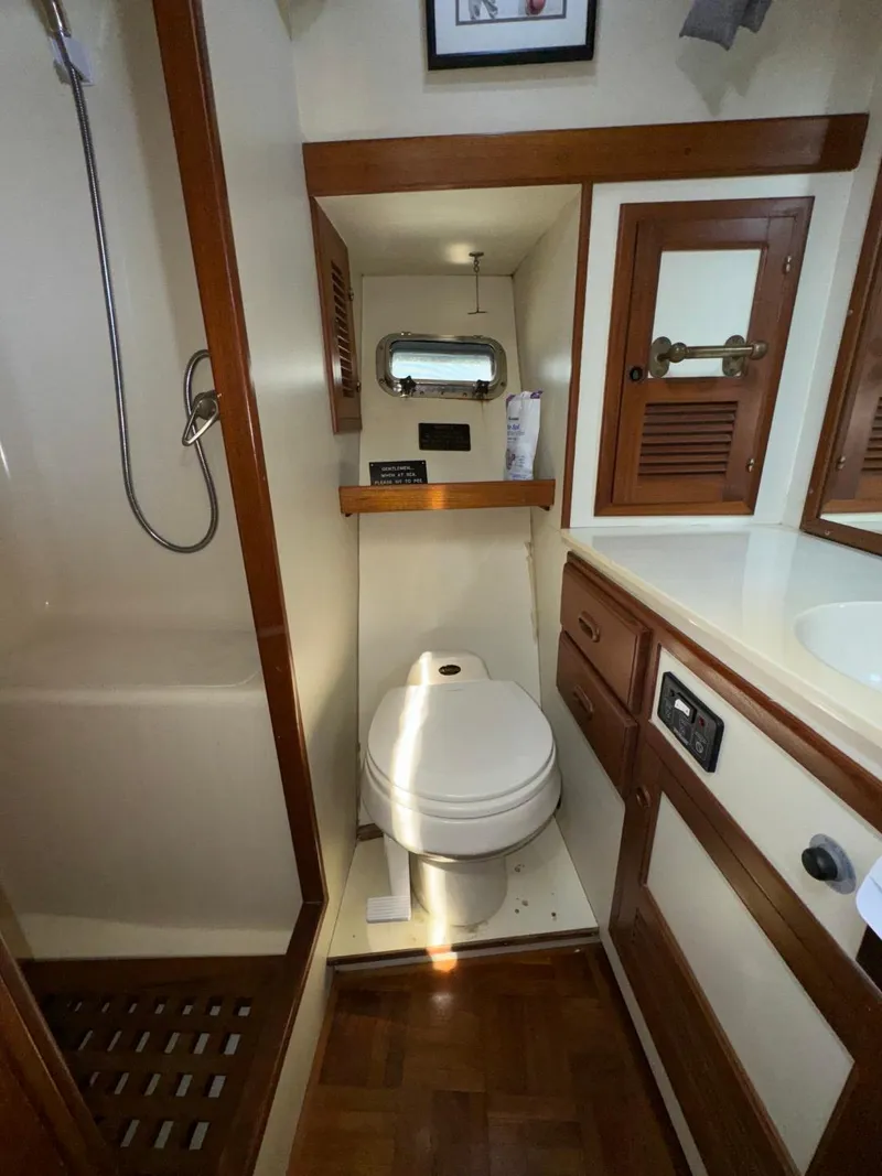 Slide: The Image of 1987 Kadey-Krogen Silhouette yacht bathroom with shower, toilet, and wooden cabinetry. - 22