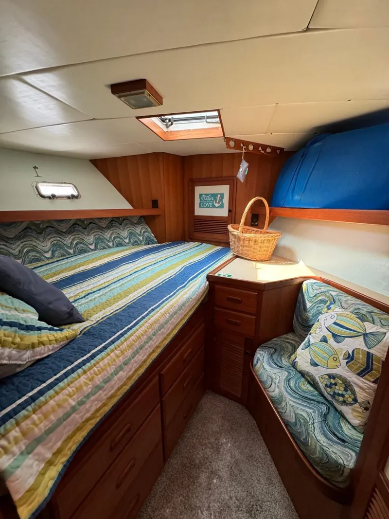 Slide: The Image of 1987 Kadey-Krogen Silhouette cabin with cozy bed, wooden storage, and nautical decor. - 24