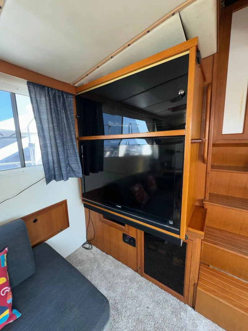 Slide: The Image of 1987 Kadey-Krogen Silhouette interior with TV, wooden cabinetry, and stairs. - 3