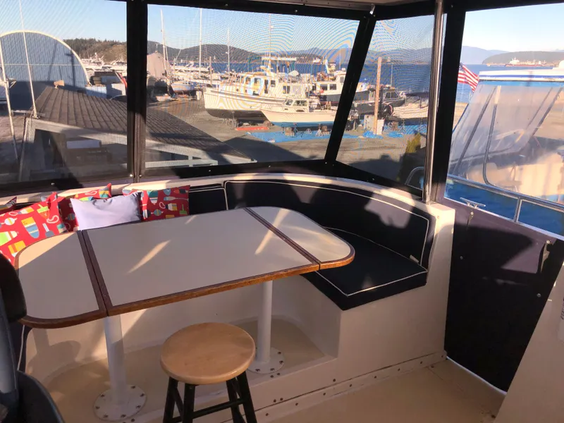 Slide: The Image of 1987 Kadey-Krogen Silhouette boat interior with table, seating, and marina view. - 32