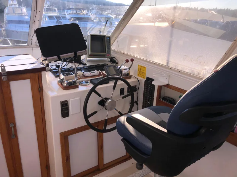 Slide: The Image of 1987 Kadey-Krogen Silhouette helm with steering wheel, navigation equipment, and captain's chair. - 34