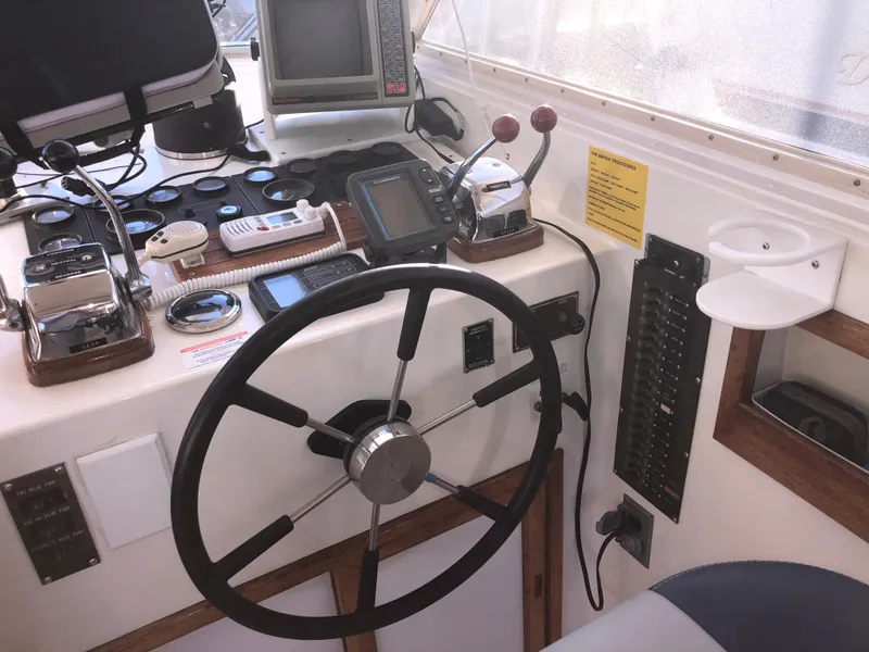 Slide: The Image of 1987 Kadey-Krogen Silhouette boat helm with steering wheel, controls, and navigation equipment. - 36