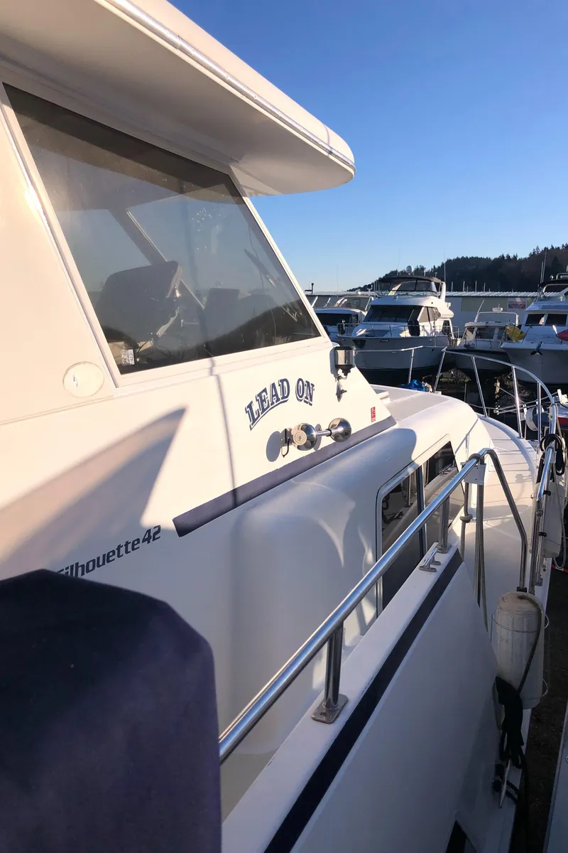 Slide: The Image of 1987 Kadey-Krogen Silhouette yacht docked, showcasing sleek design and sunny marina setting. - 39