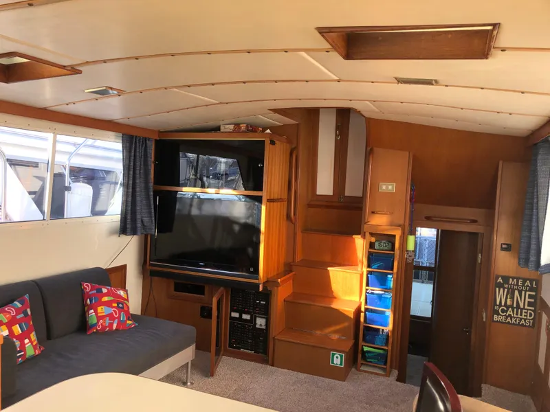 Slide: The Image of 1987 Kadey-Krogen Silhouette interior with cozy seating, TV, and wooden cabinetry. - 4