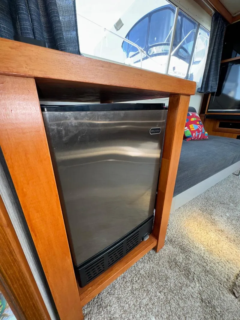 Slide: The Image of 1987 Kadey-Krogen Silhouette interior with stainless steel mini fridge and wooden cabinetry. - 8