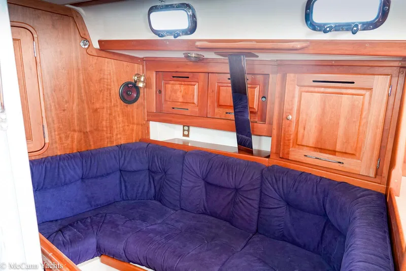 Slide: The Image of Interior of 2002 Tartan 3700 yacht with blue cushioned seating and wooden cabinetry. - 15
