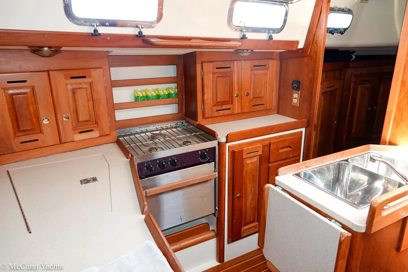 Slide: The Image of Interior of 2002 Tartan 3700 yacht with wooden cabinetry and compact kitchen area. - 17