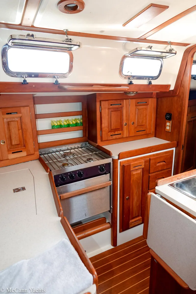 Slide: The Image of Interior of 2002 Tartan 3700 sailboat with wooden cabinetry and compact kitchen area. - 18