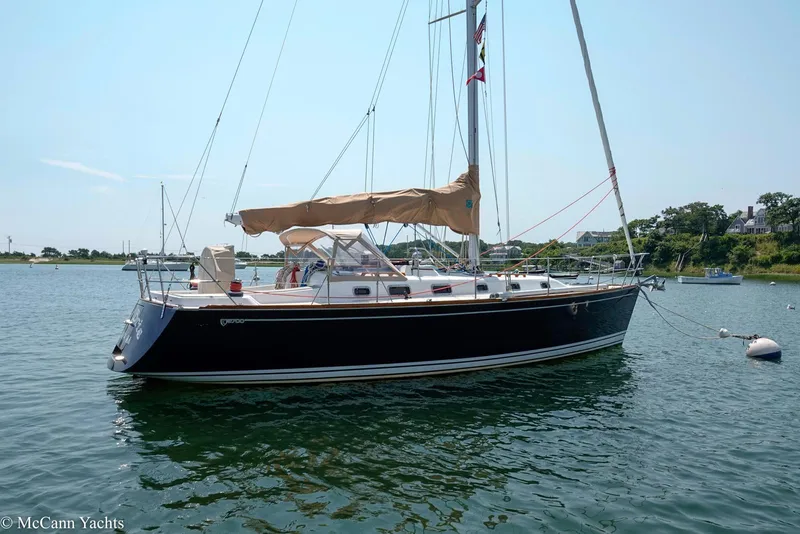 Slide: The Image of Sailboat Tartan 3700, 2002 model, anchored in calm waters under a clear sky. - 2