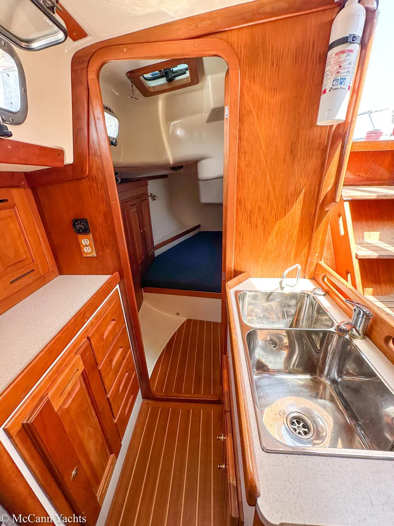Slide: The Image of 2002 Tartan 3700 yacht interior with wooden cabinetry and stainless steel sink. - 22