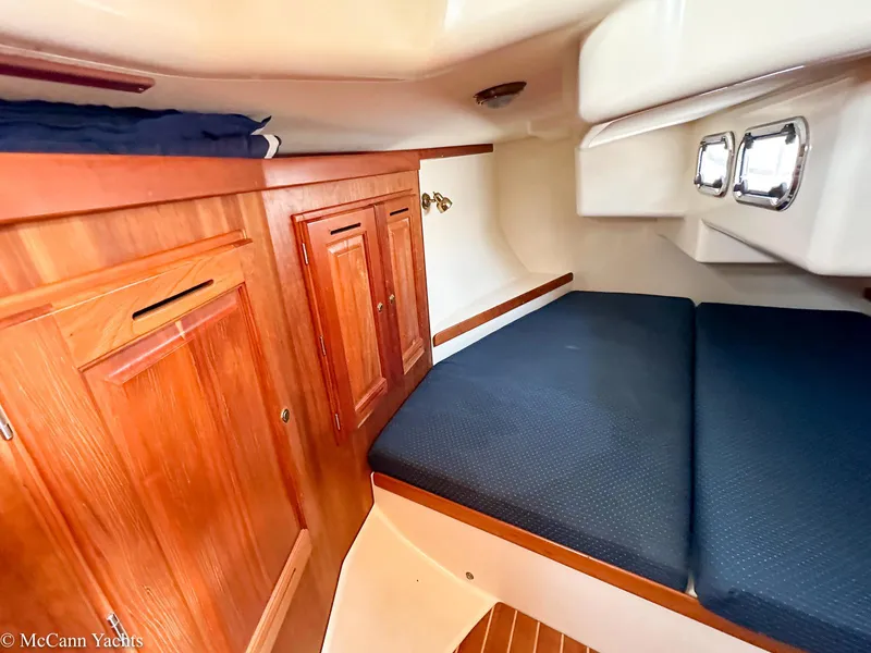 Slide: The Image of Cozy cabin interior of 2002 Tartan 3700 yacht with wooden cabinetry and cushioned seating. - 23