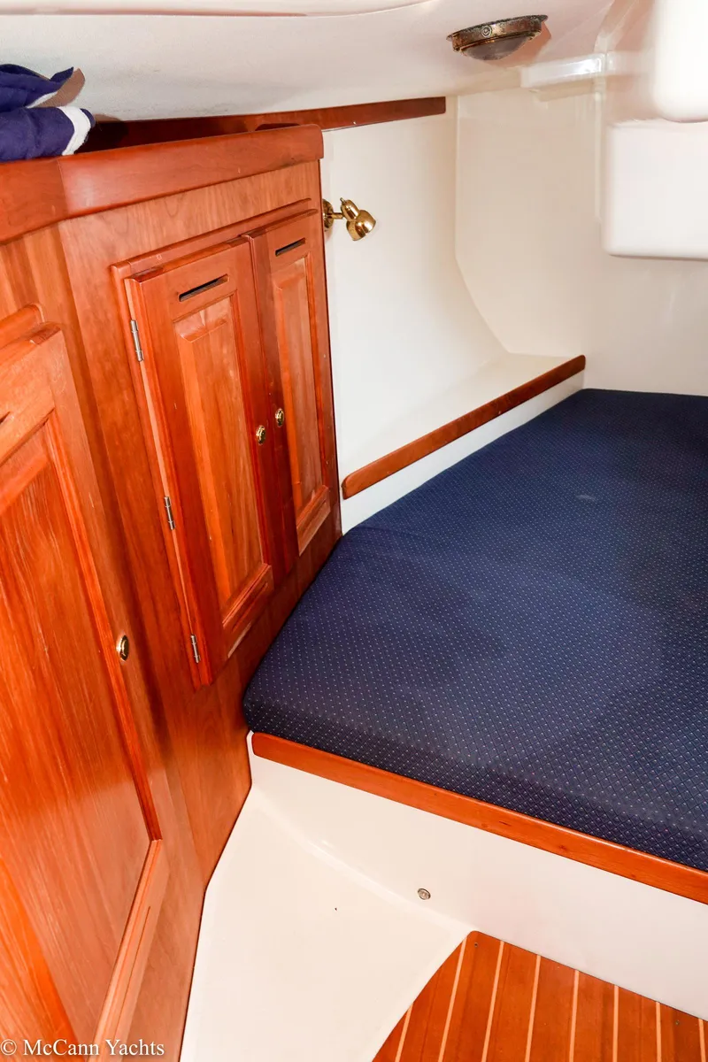 Slide: The Image of Cozy cabin interior of 2002 Tartan 3700 yacht with wooden cabinetry and blue bedding. - 24