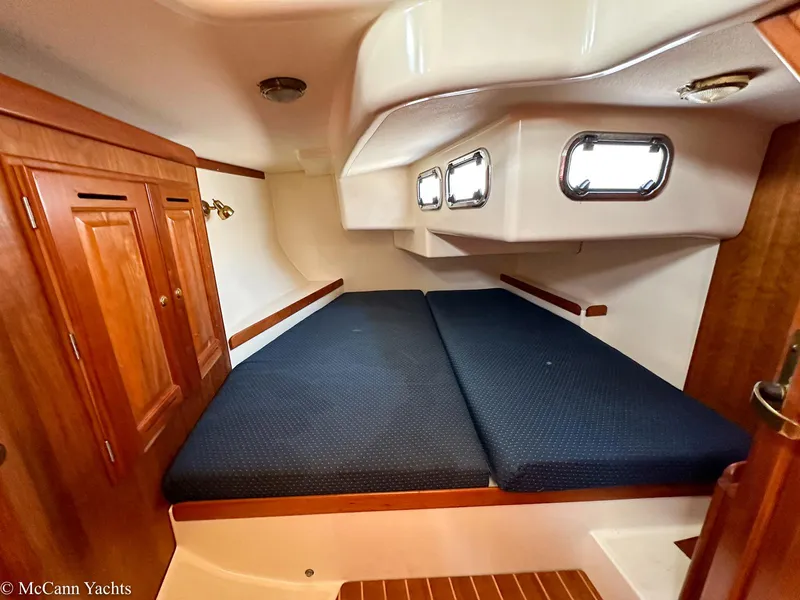 Slide: The Image of Cozy cabin interior of 2002 Tartan 3700 yacht with wooden cabinetry and blue bedding. - 25