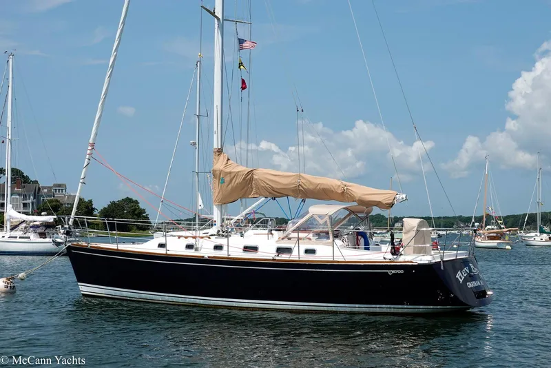 Slide: The Image of Sailboat Tartan 3700, 2002 model, anchored in a scenic harbor with clear skies. - 3
