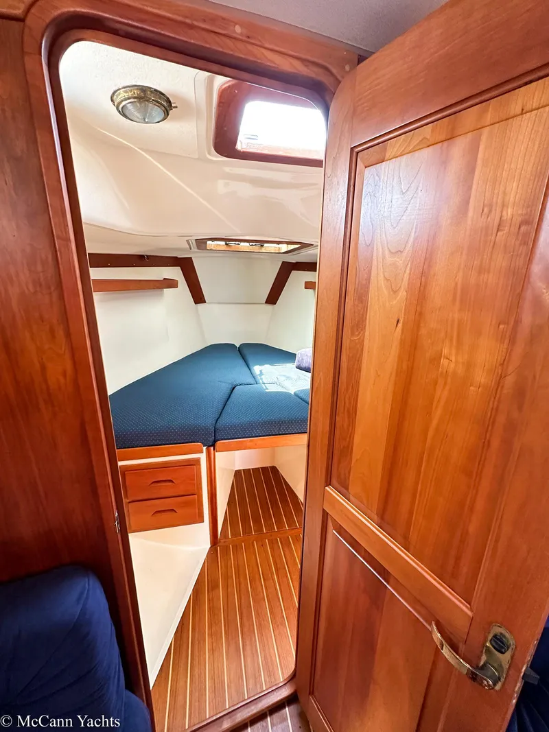 Slide: The Image of Interior cabin of a 2002 Tartan 3700 yacht with wooden finishes and blue bedding. - 32
