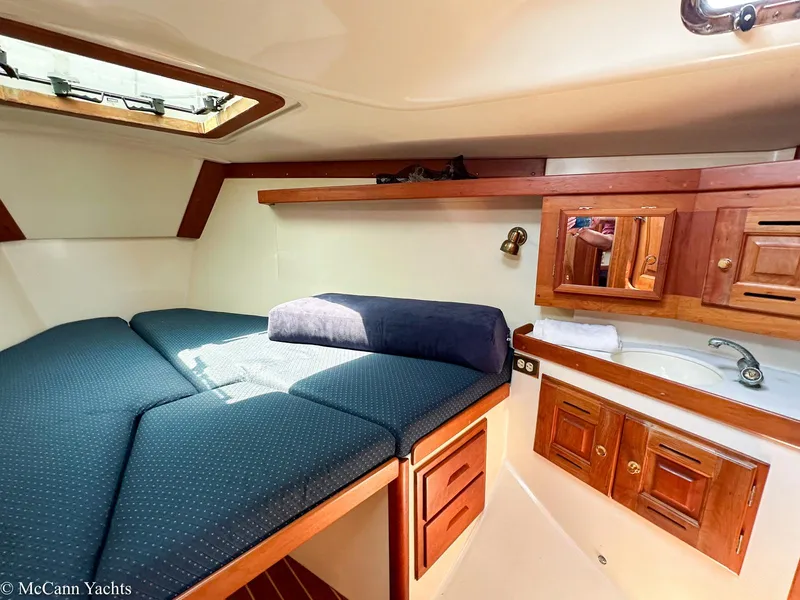 Slide: The Image of Cozy cabin interior of 2002 Tartan 3700 yacht with bed, sink, and wooden cabinets. - 34