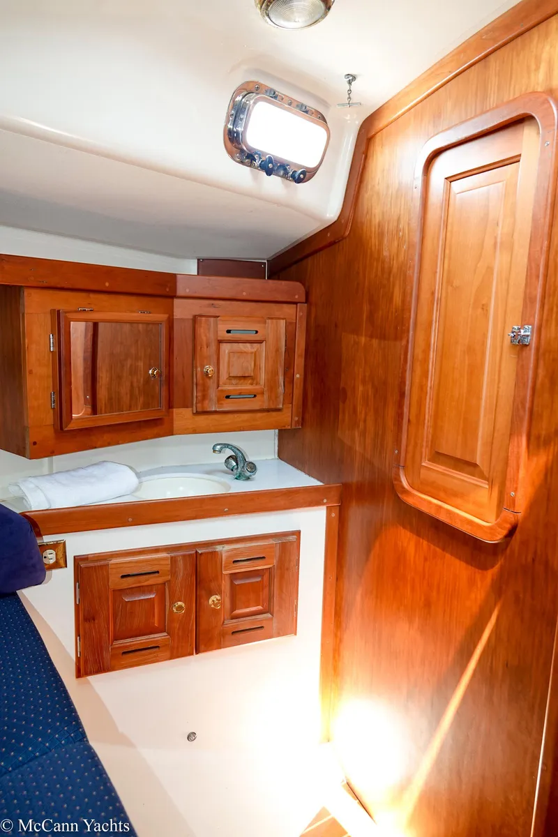 Slide: The Image of Wood-paneled cabin interior of 2002 Tartan 3700 yacht with storage cabinets and porthole. - 37