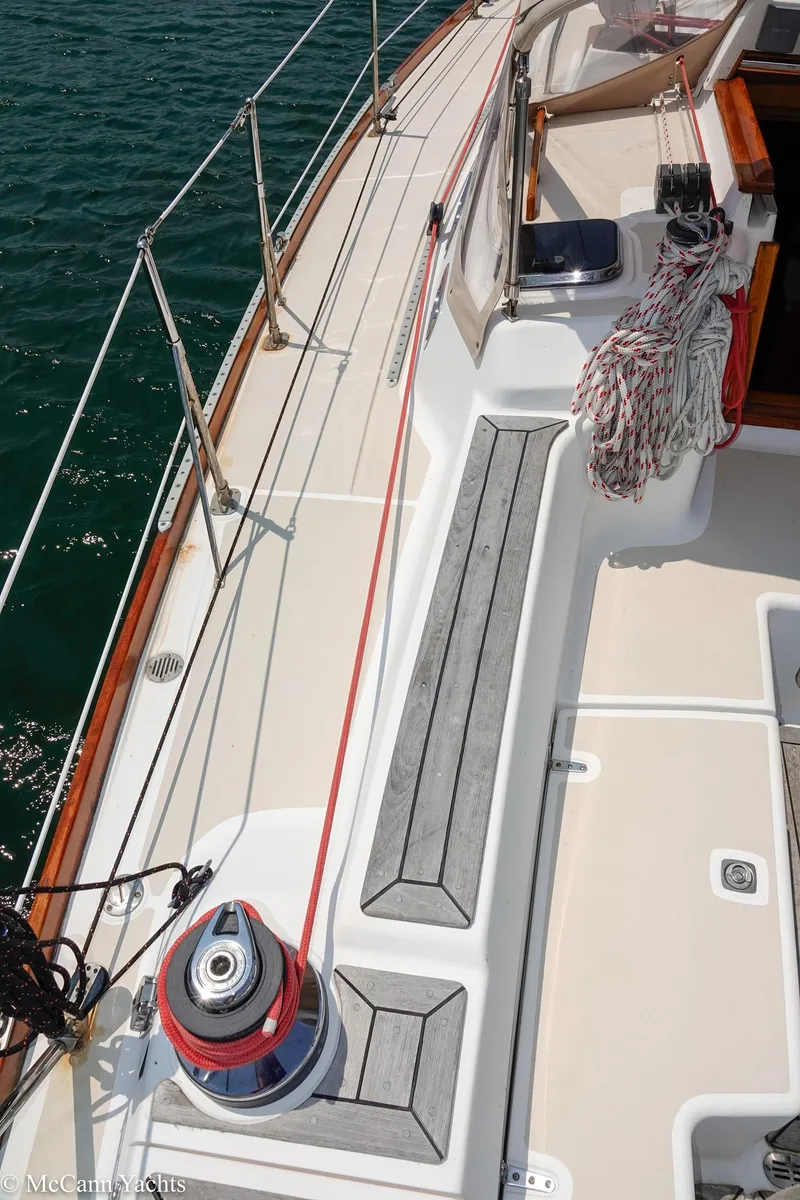 Slide: The Image of Deck of 2002 Tartan 3700 sailboat with winch and ropes, docked on calm water. - 48