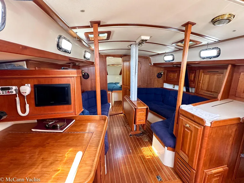 Slide: The Image of Interior of 2002 Tartan 3700 yacht with wooden furnishings and blue seating. - 8