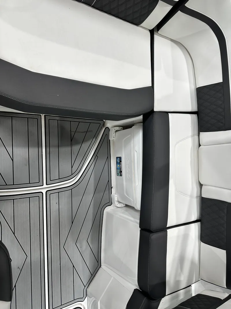 Slide: The Image of 2024 Monterey M6 boat interior with sleek black and white seating and modern flooring design. - 10