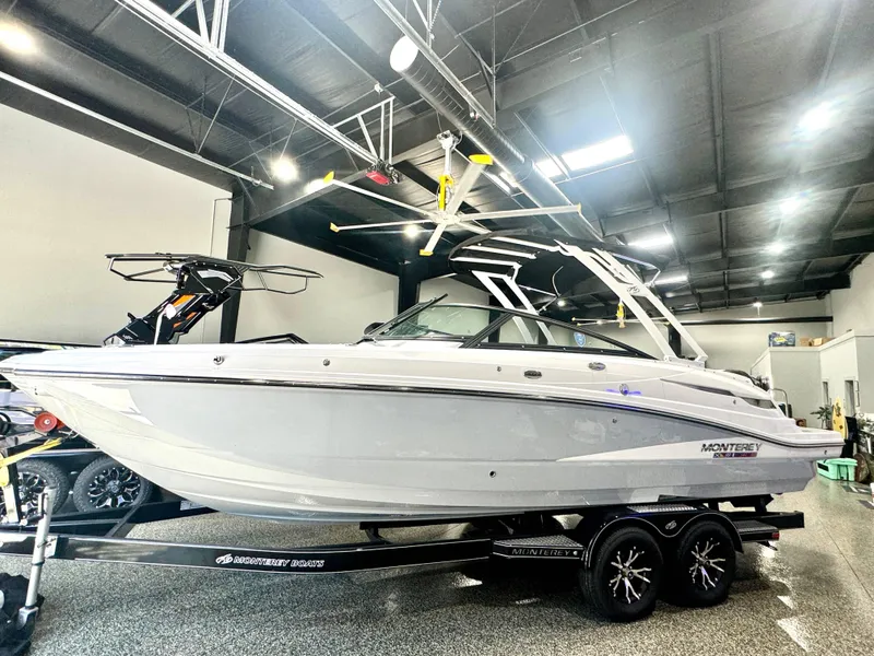 Slide: The Image of 2024 Monterey M6 boat in showroom, sleek design, on trailer. - 2
