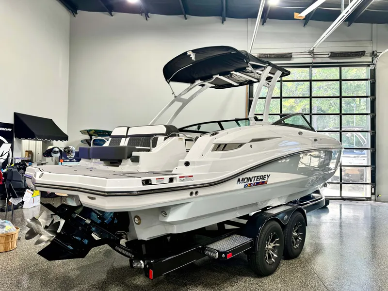 Slide: The Image of 2024 Monterey M6 boat in showroom, sleek design, dual-axle trailer. - 3