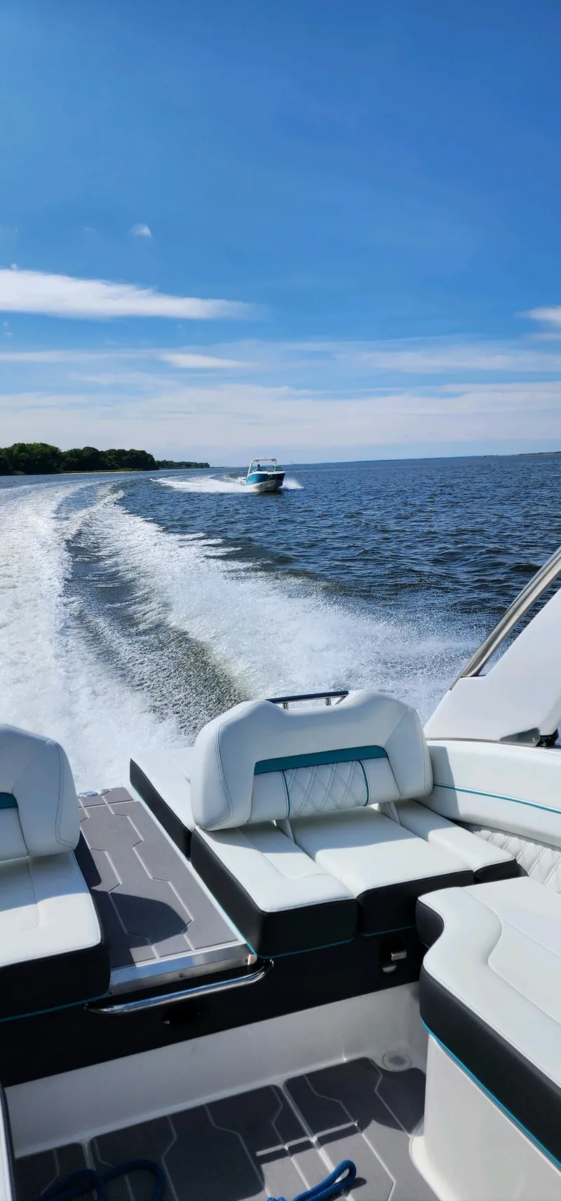 Slide: The Image of 2023 Regal LS6 boat cruising on open water under a clear blue sky. - 12