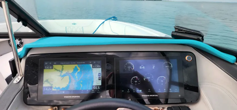 Slide: The Image of Dashboard of a 2023 Regal LS6 boat with navigation and control screens on a calm lake. - 6