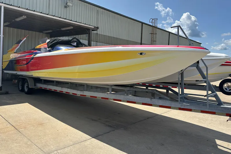 Slide: The Image of 2003 Hustler 377 Talon speedboat on trailer, vibrant yellow and red design. - 11