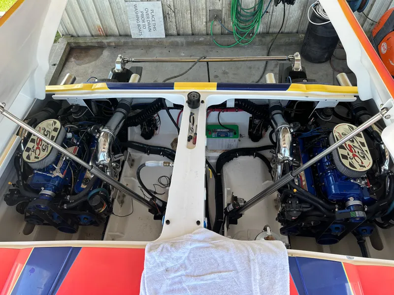 Slide: The Image of 2003 Hustler 377 Talon boat engine compartment with dual engines and vibrant detailing. - 8