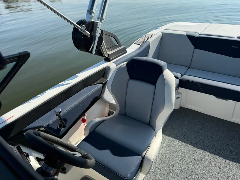Slide: The Image of 2022 MasterCraft NXT20 boat interior with sleek seating and steering wheel. - 10