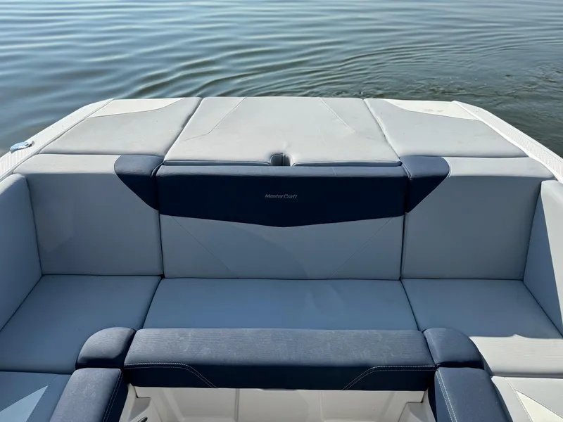 Slide: The Image of 2022 MasterCraft NXT20 boat interior with gray and navy seating on calm water. - 14