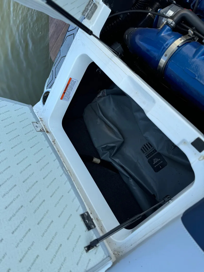 Slide: The Image of Open storage compartment in 2022 MasterCraft NXT20 boat. - 20