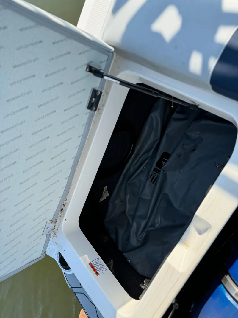 Slide: The Image of Open storage compartment in 2022 MasterCraft NXT20 boat. - 21