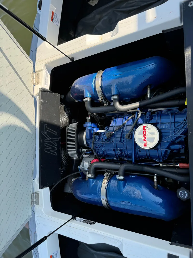 Slide: The Image of 2022 MasterCraft NXT20 engine compartment with Ilmor engine, blue components visible. - 22