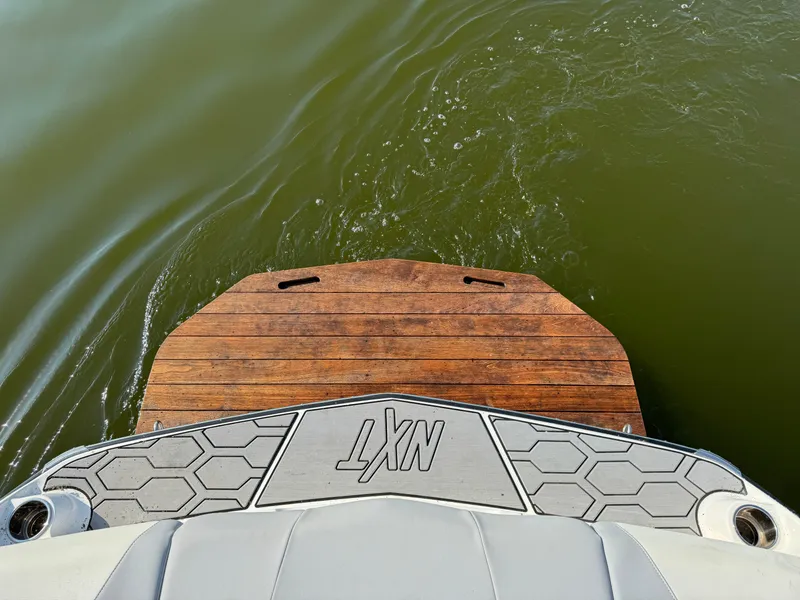 Slide: The Image of 2022 MasterCraft NXT20 boat platform on water, showcasing sleek design. - 34